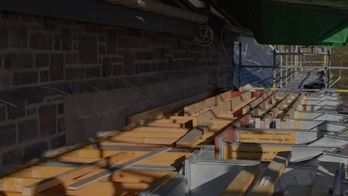Designed temporary support carrying the wall above while the opening below is formed