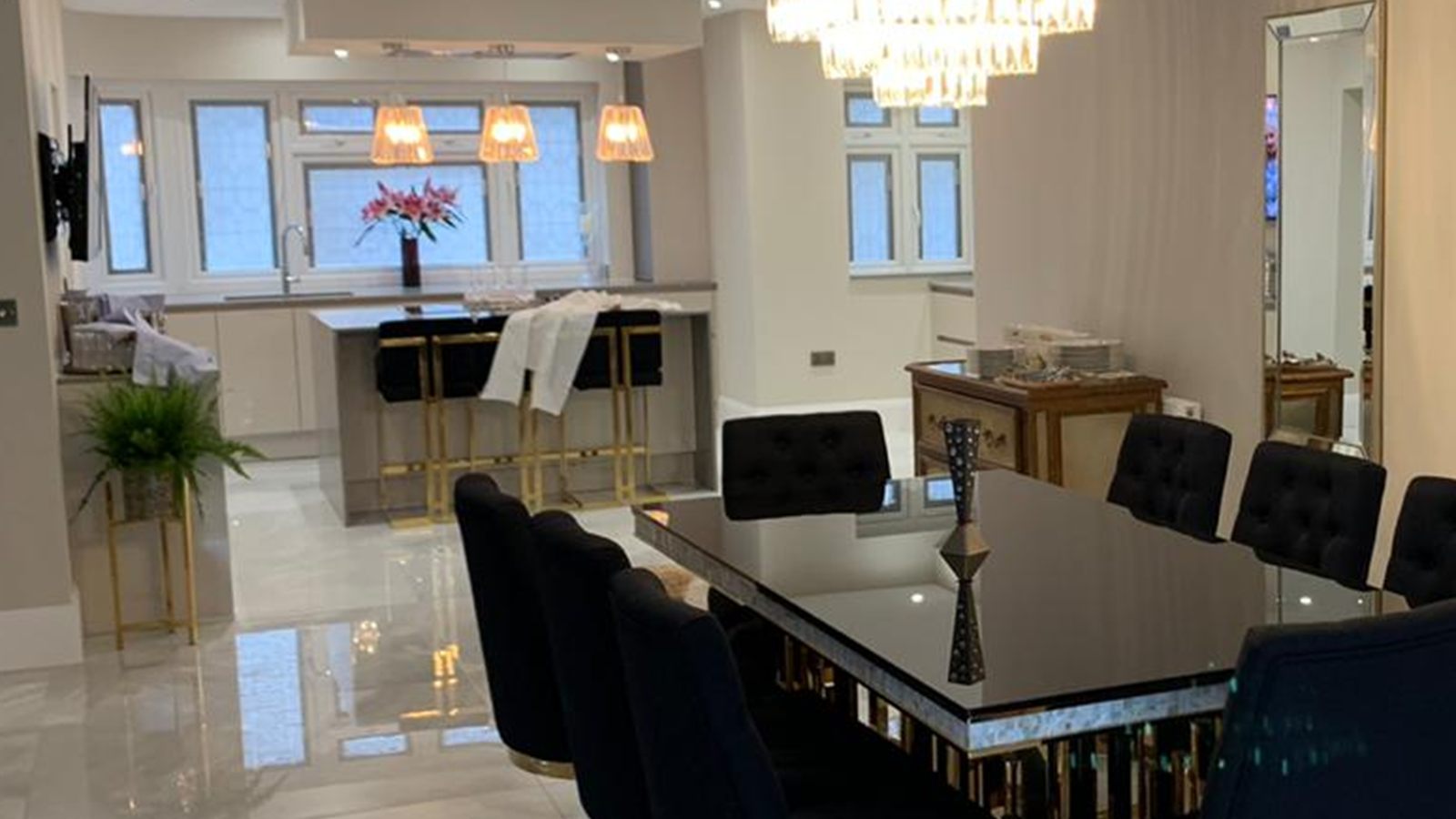 The dining area, looking through to the kitchen beyond, with polished stone floors running throughout