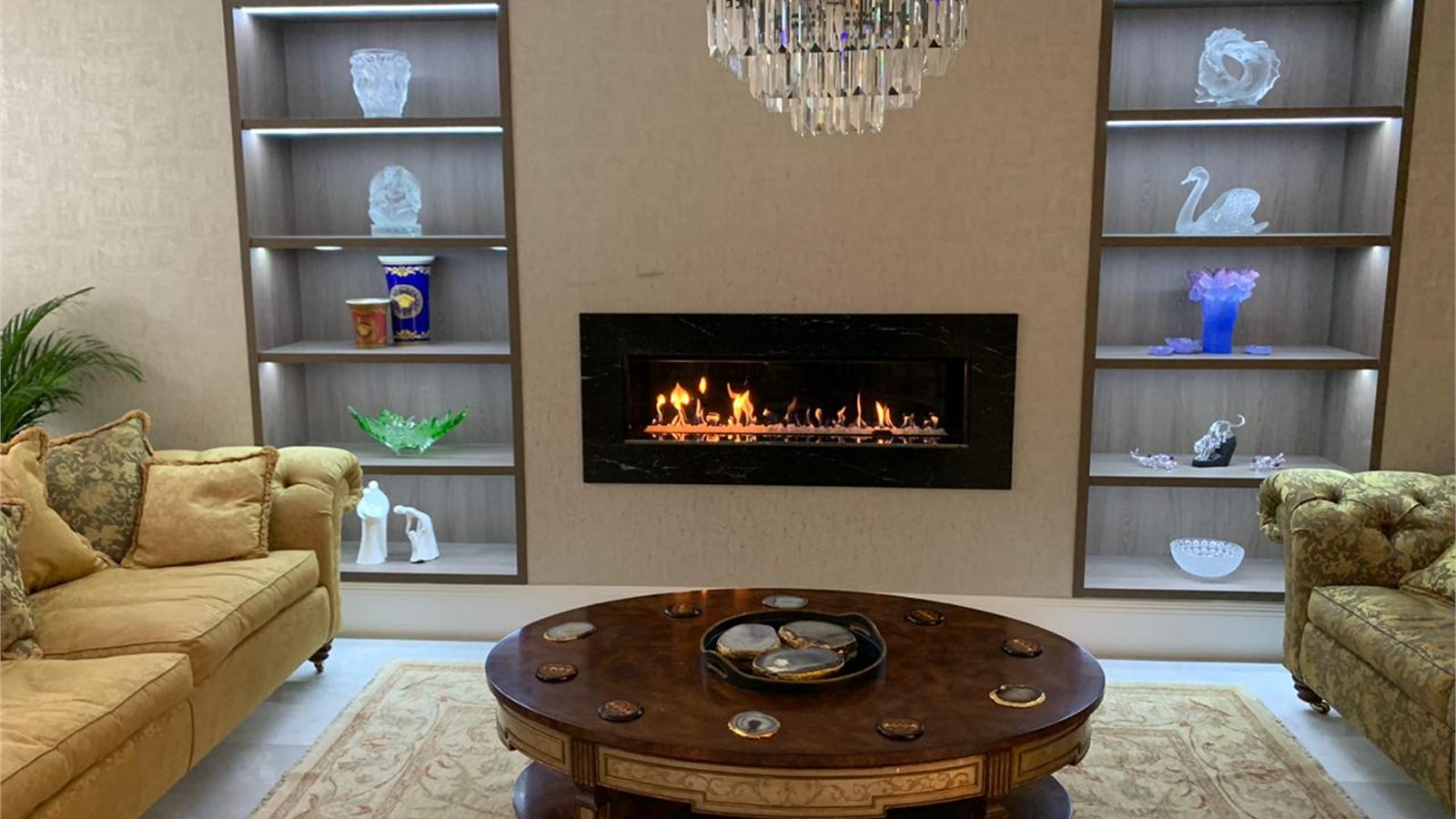 The living room, with a linear gas fire set into a stone surround between lit display recesses